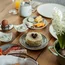 Frühstückstisch mit Pfannkuchen, Kaffee, Ei, Käse, Aufschnitt und Blumen